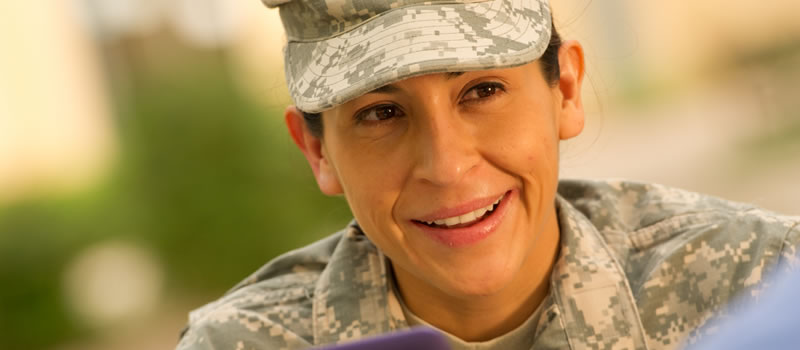 Female military student looking up from laptop