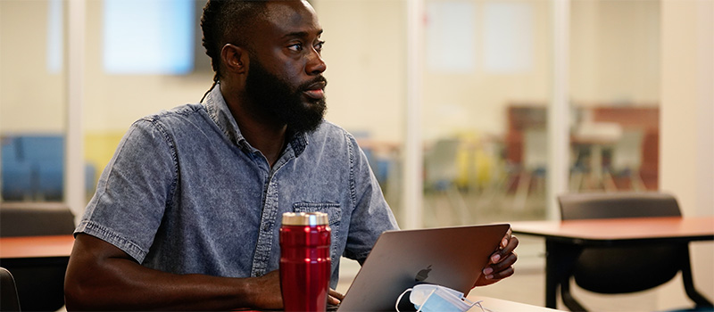 Male student sits in front in a computer