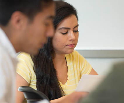 Female student looking down at paper in class