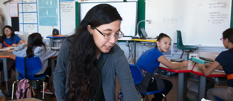 Student assisting children in classroom