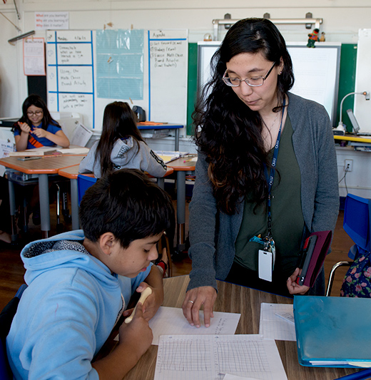 Student helping child in classroom